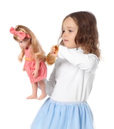 Photo of Cute little girl brushing doll's hair on white background