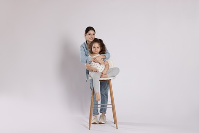 Photo of Portrait of cute sisters on white background