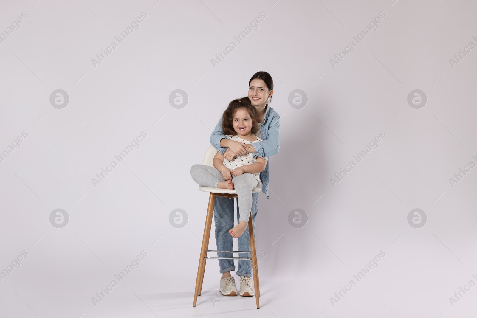 Photo of Portrait of cute sisters on white background