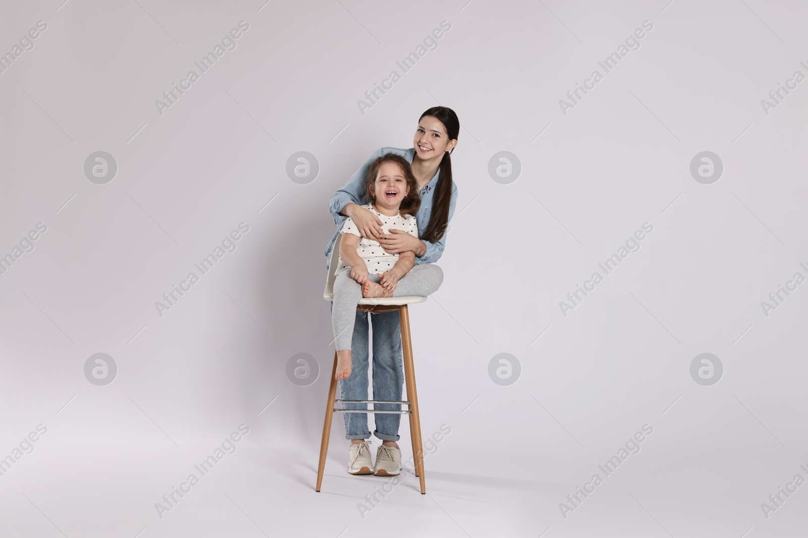 Photo of Portrait of cute sisters on white background