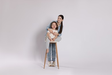 Photo of Portrait of cute sisters on white background