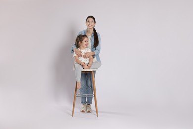 Photo of Portrait of cute sisters on white background