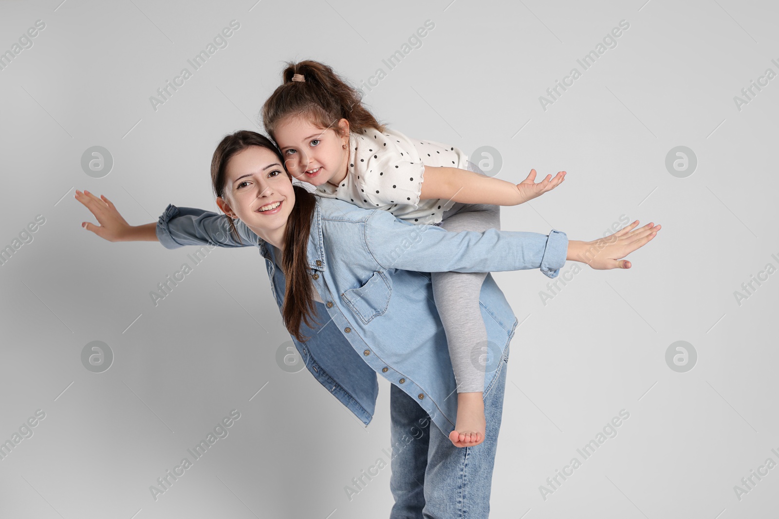 Photo of Portrait of cute sisters on white background