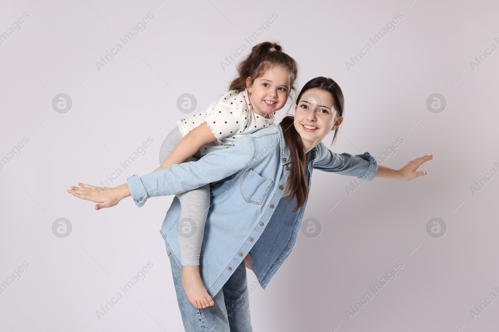 Photo of Portrait of cute sisters on white background