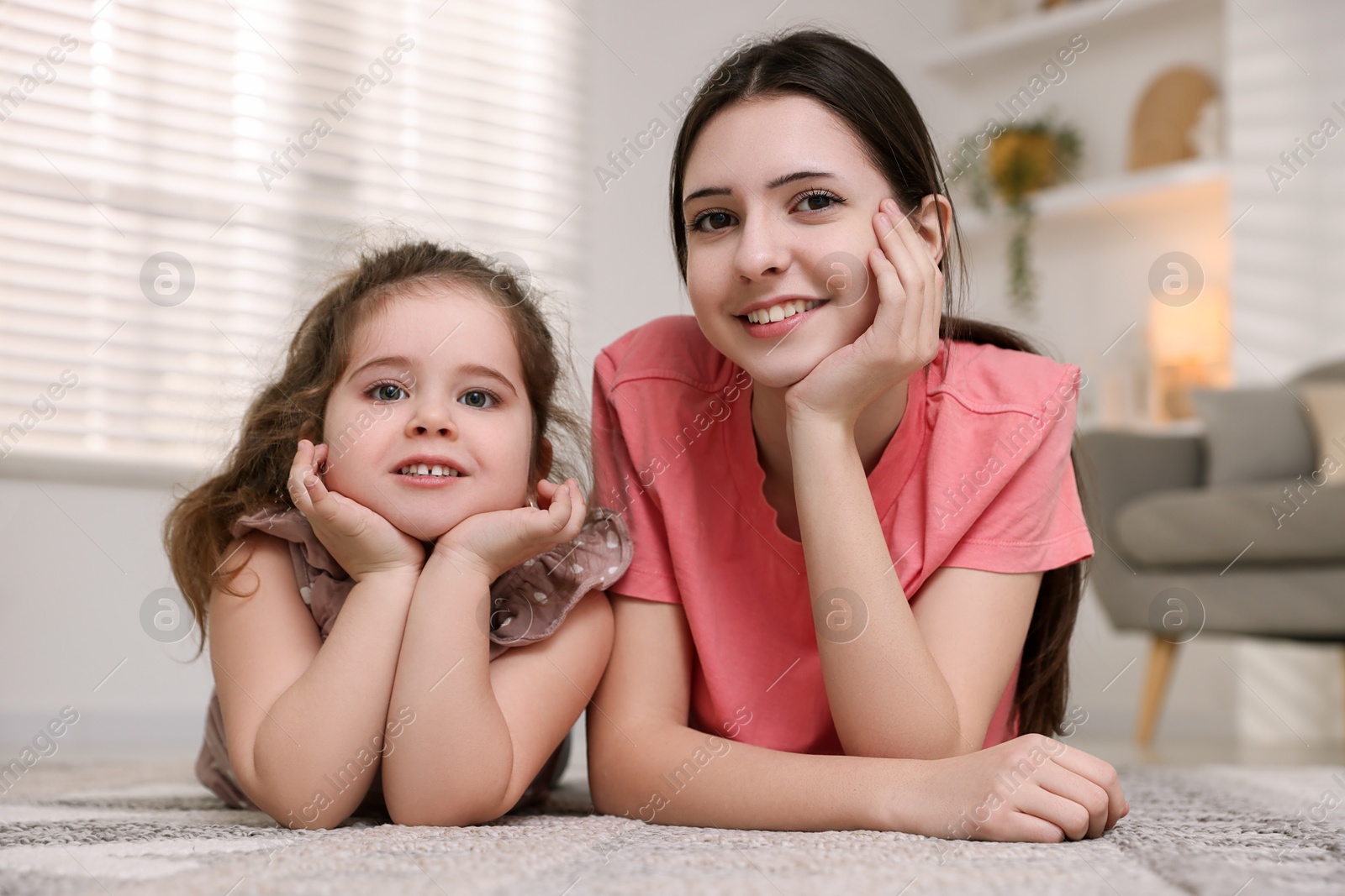 Photo of Portrait of cute little girl and her sister indoors