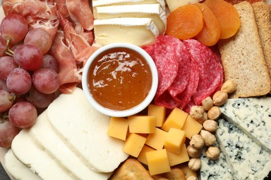 Photo of Different types of cut cheese and other snacks on table, top view