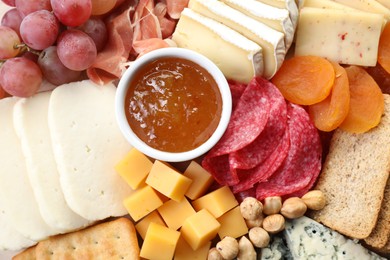 Photo of Different types of cut cheese and other snacks, top view