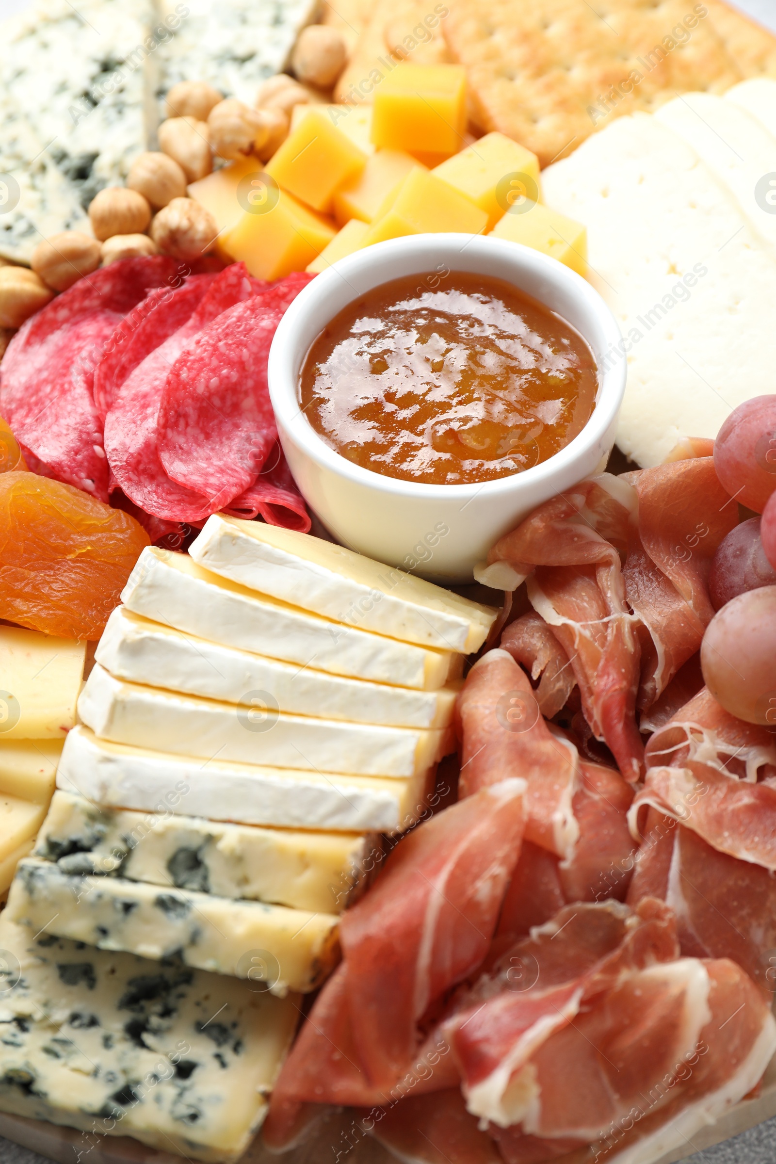 Photo of Different types of cut cheese and other snacks, closeup