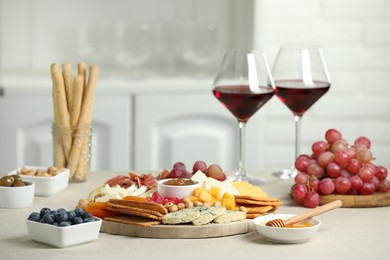 Photo of Different types of cut cheese and other snacks on light textured table, closeup