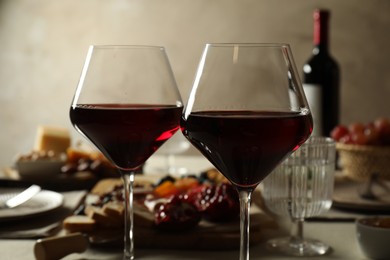 Photo of Red wine and different snacks served on table, closeup