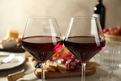 Photo of Red wine and different snacks served on table, closeup