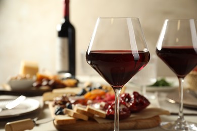 Photo of Red wine and different snacks served on table, closeup. Space for text