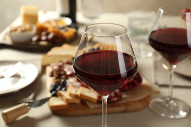 Photo of Red wine and different snacks served on table, closeup