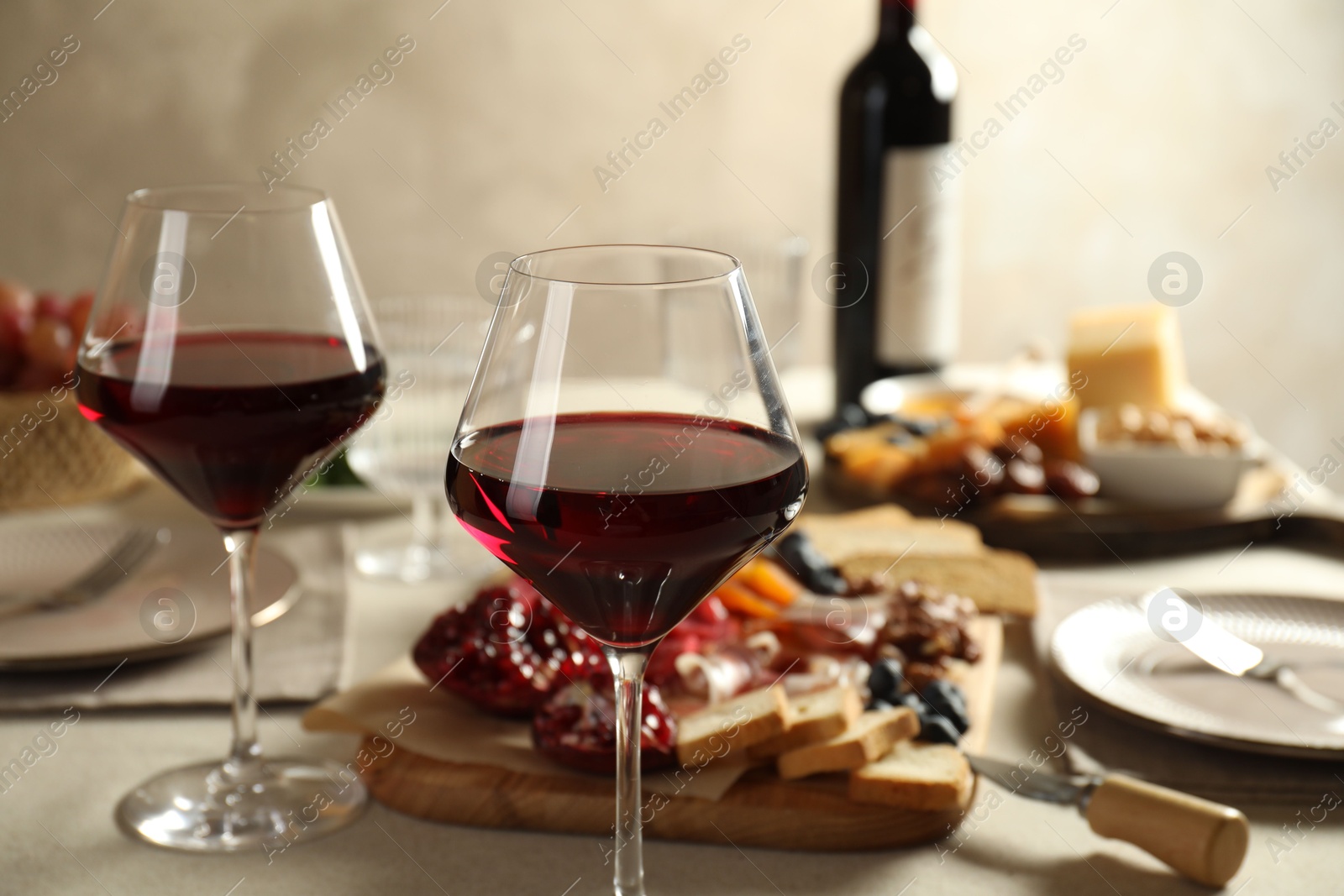 Photo of Red wine and different snacks served on table, closeup