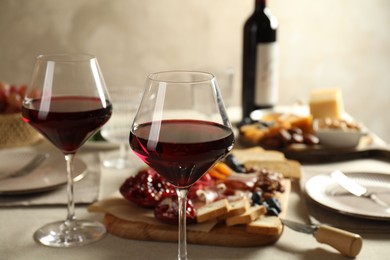 Photo of Red wine and different snacks served on table, closeup