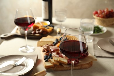 Photo of Red wine and different snacks served on table, closeup