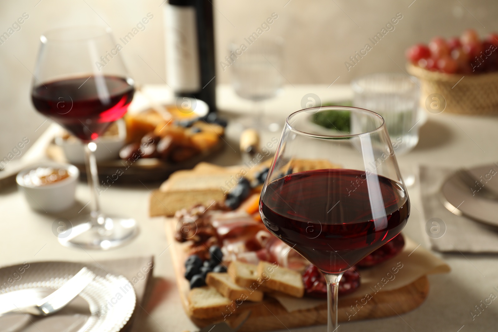 Photo of Red wine and different snacks served on table, closeup. Space for text