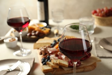 Red wine and different snacks served on table, closeup. Space for text