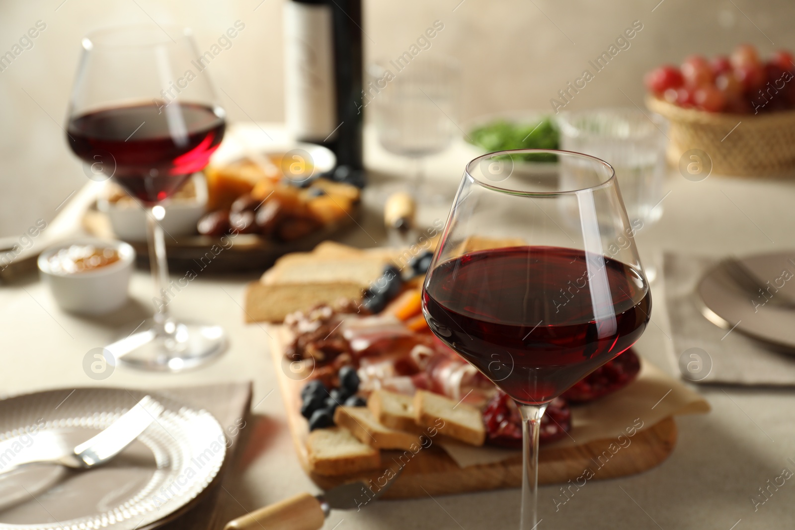 Photo of Red wine and different snacks served on table, closeup