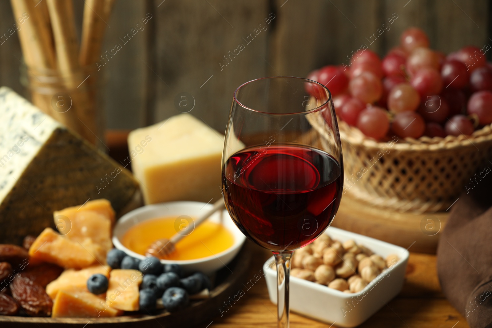 Photo of Red wine and different snacks served on table, closeup