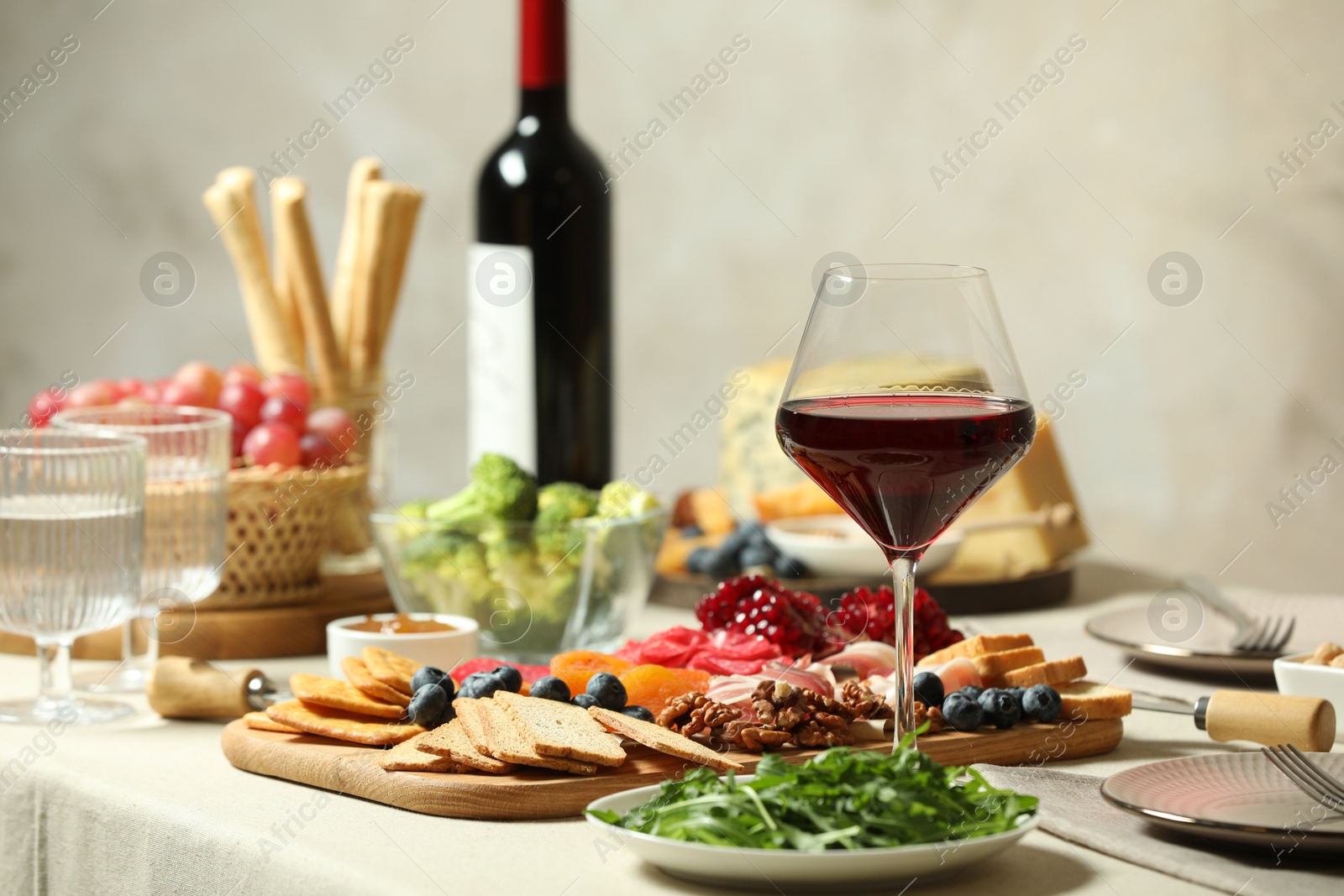 Photo of Red wine and different snacks served on table