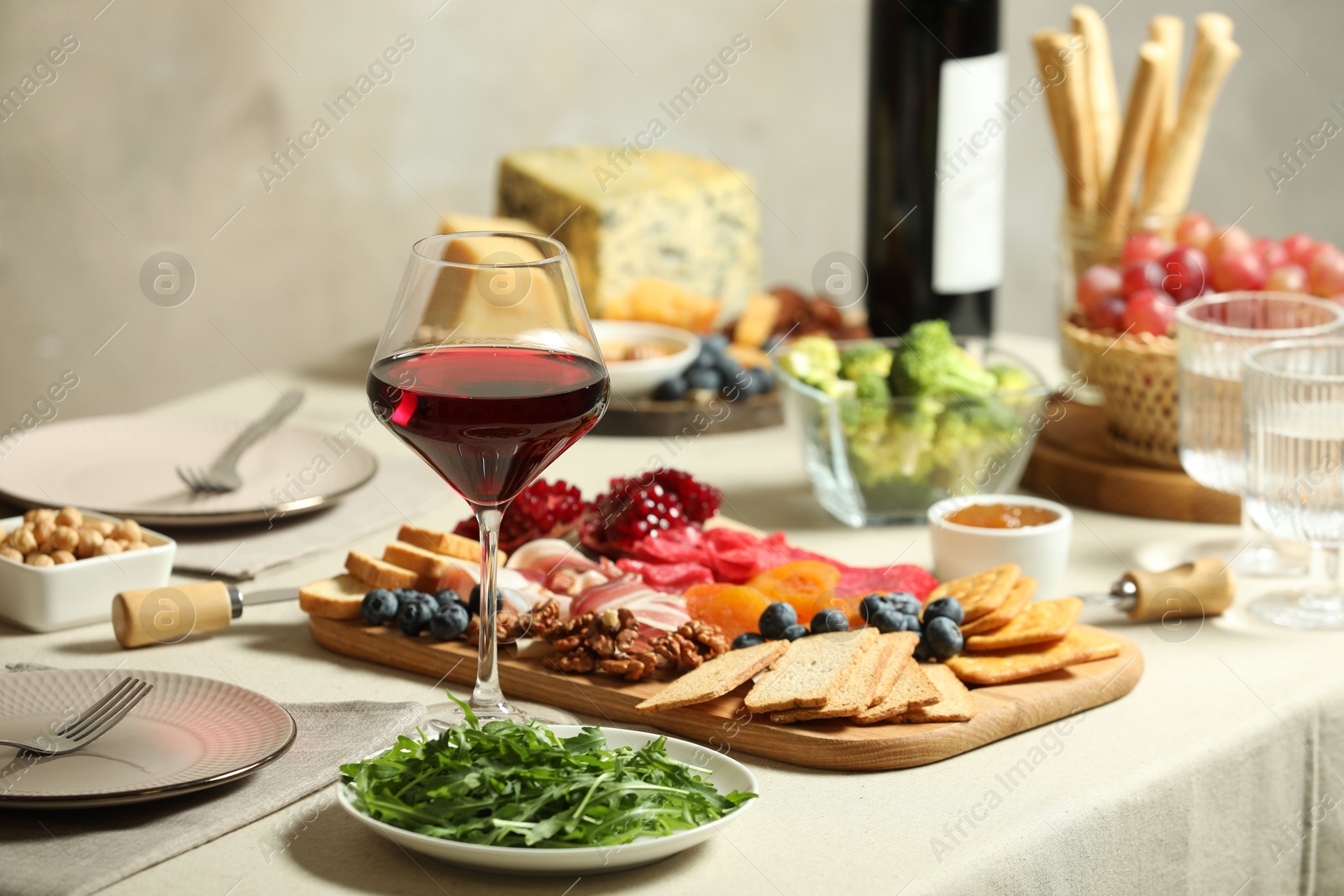 Photo of Red wine and different snacks served on table