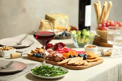 Photo of Red wine and different snacks served on table