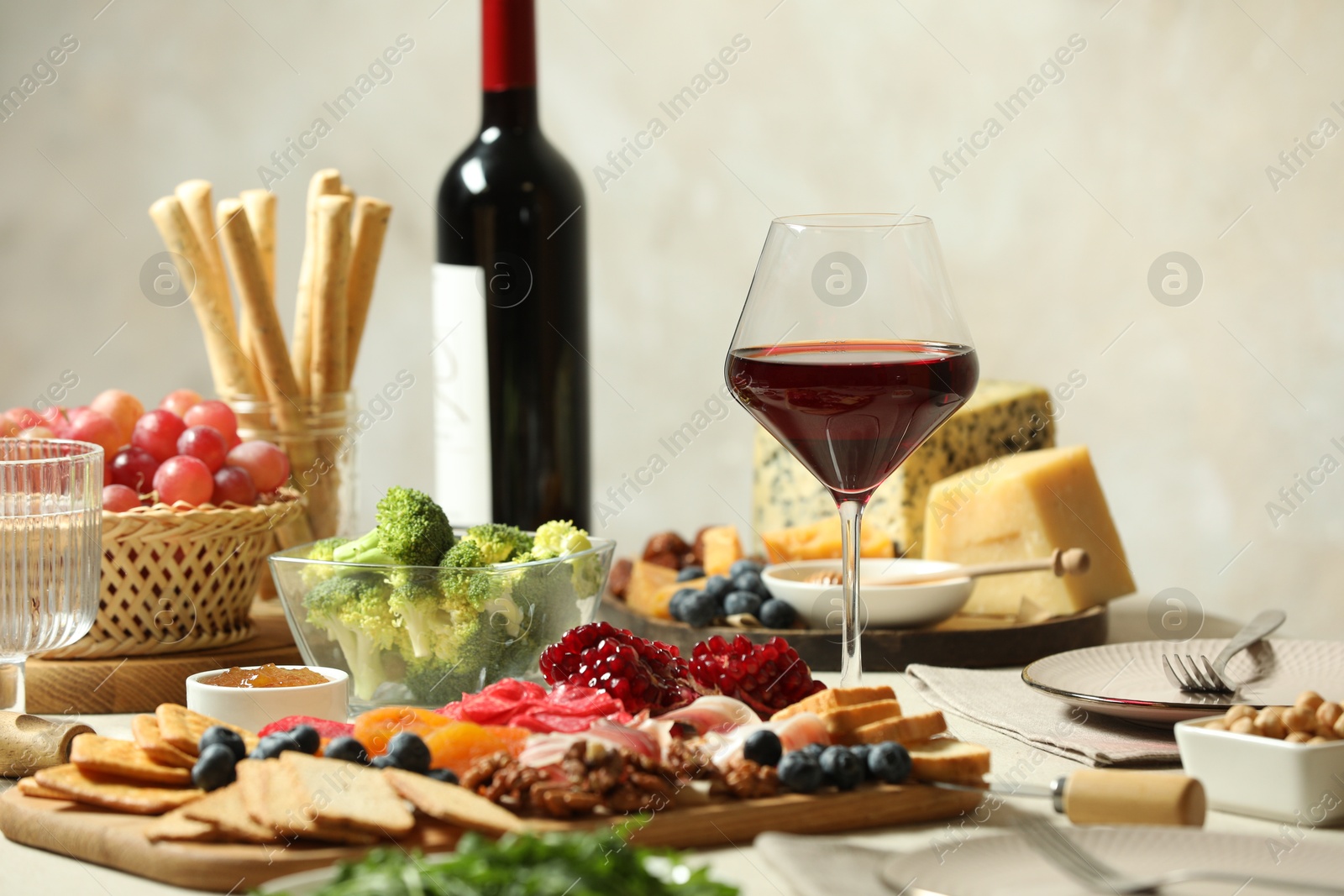 Photo of Red wine and different snacks served on table