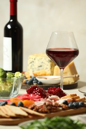 Photo of Red wine and different snacks served on table