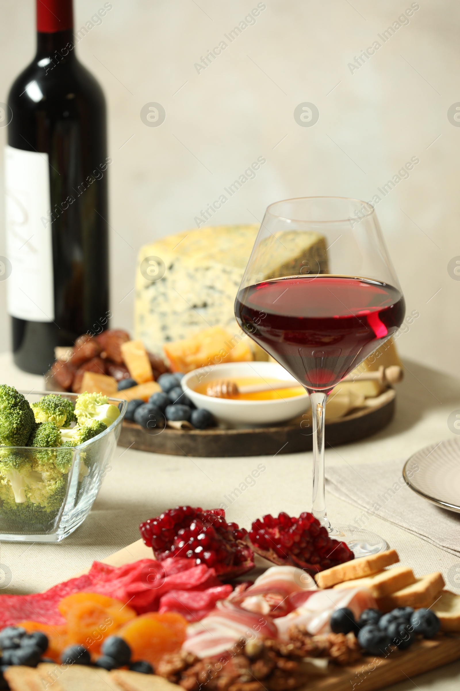 Photo of Red wine and different snacks served on table