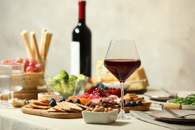 Photo of Red wine and different snacks served on table