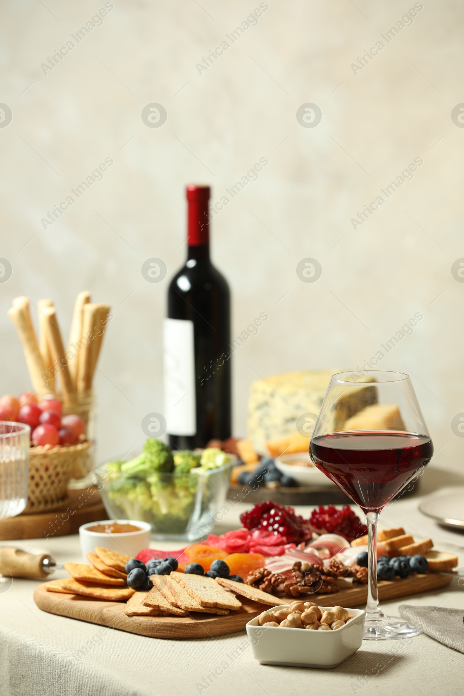 Photo of Red wine and different snacks served on table