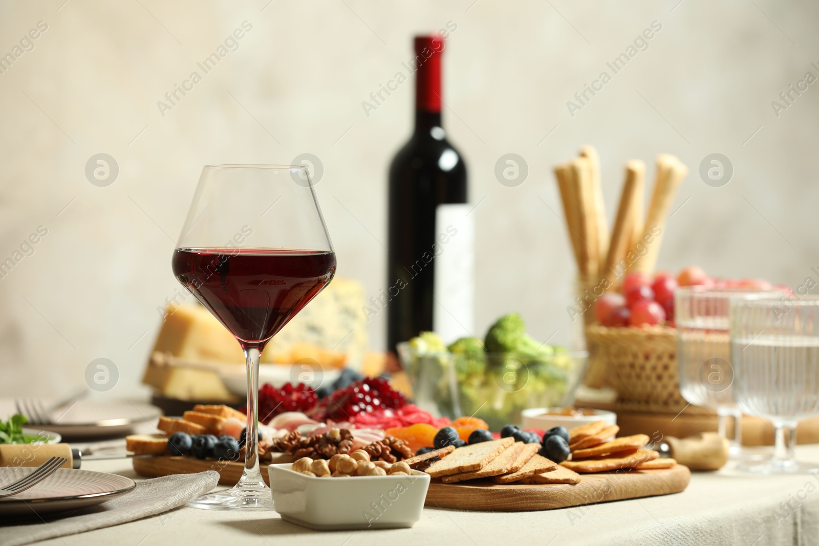 Photo of Red wine and different snacks served on table