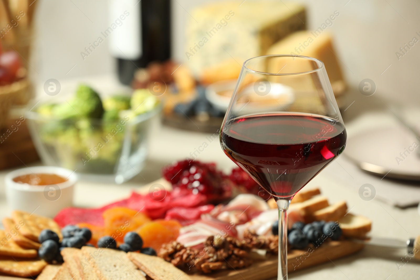 Photo of Red wine and different snacks served on table, closeup