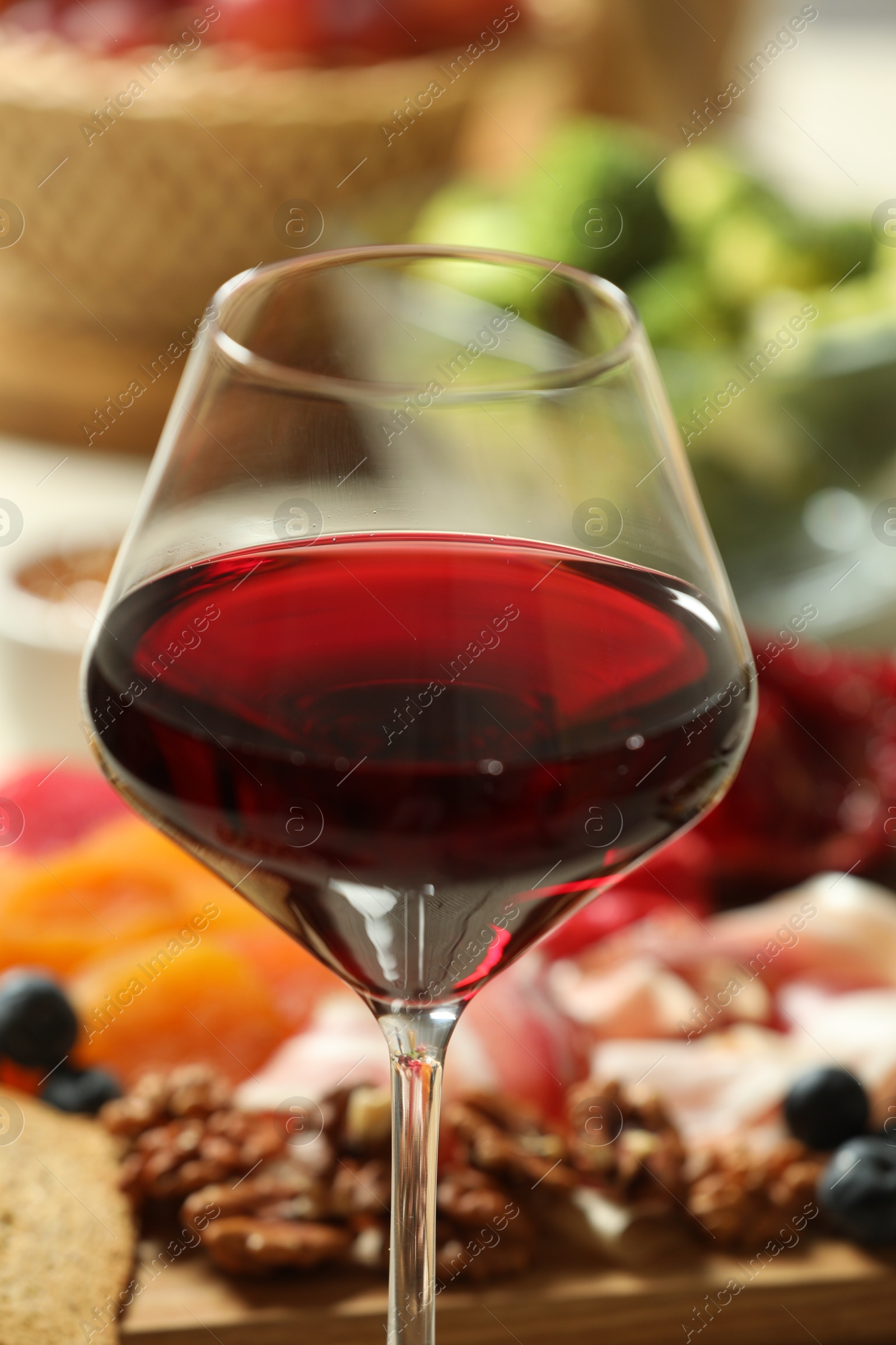 Photo of Red wine and different snacks served on table, closeup