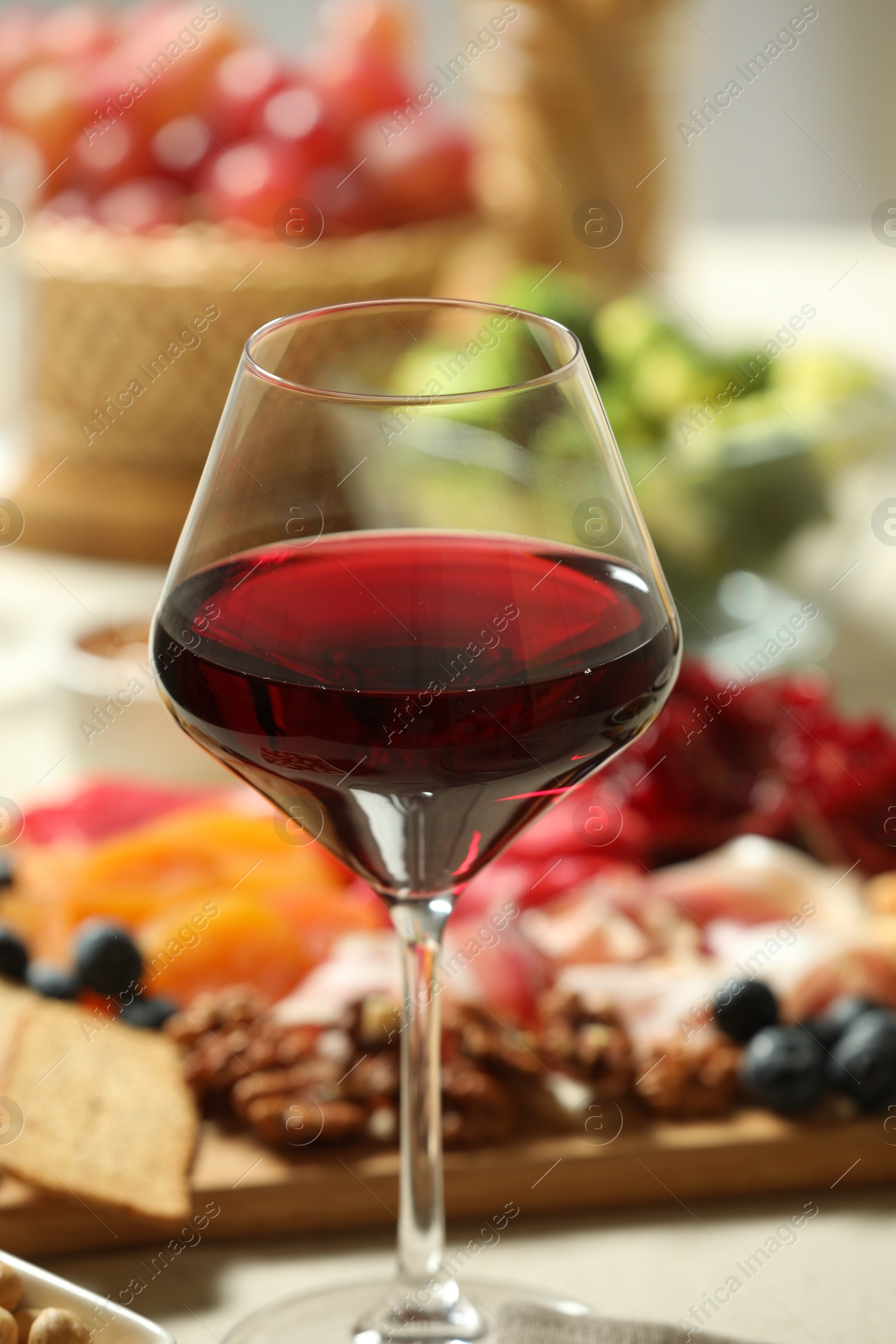 Photo of Red wine and different snacks served on table, closeup