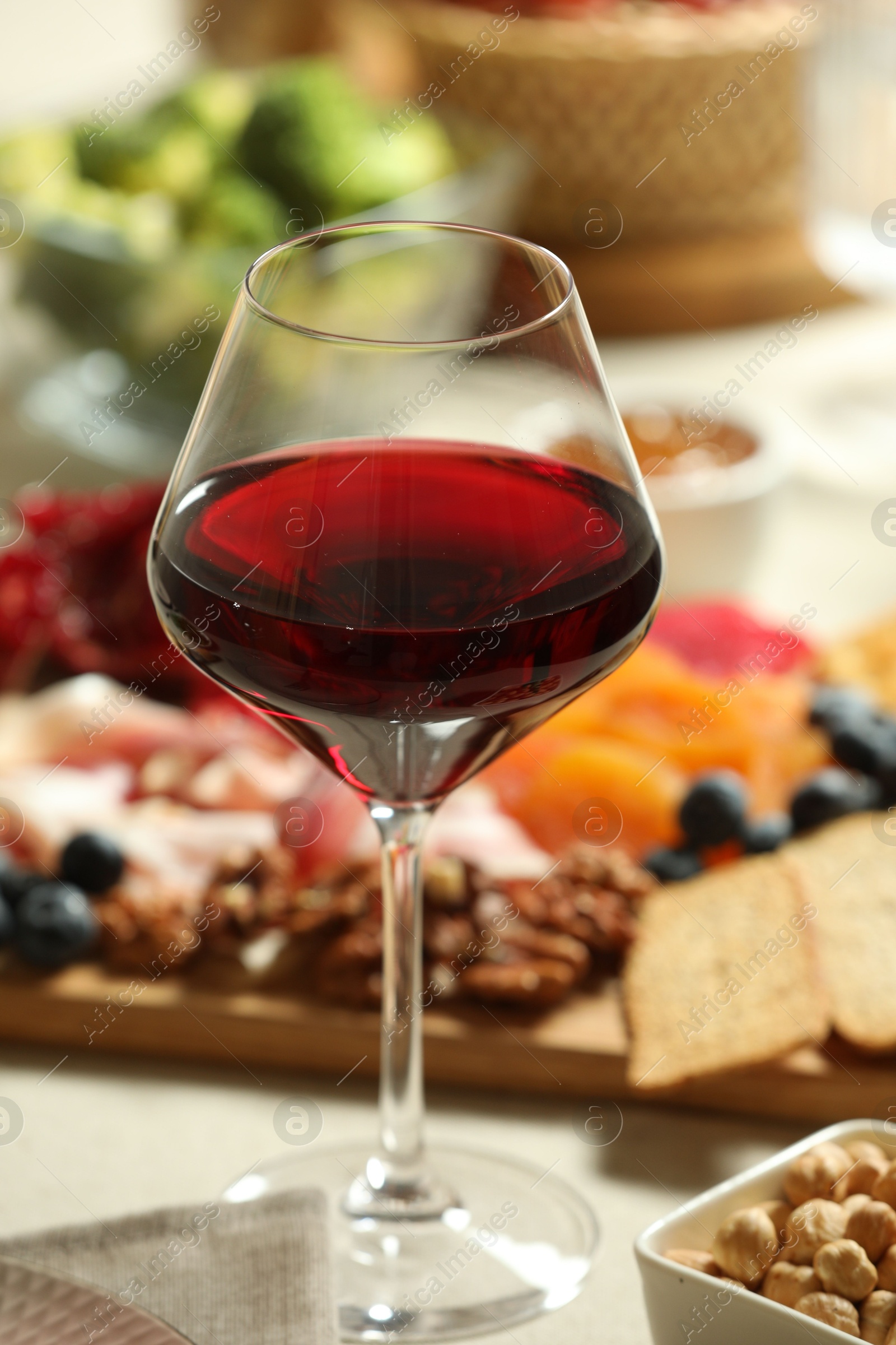 Photo of Red wine and different snacks served on table, closeup