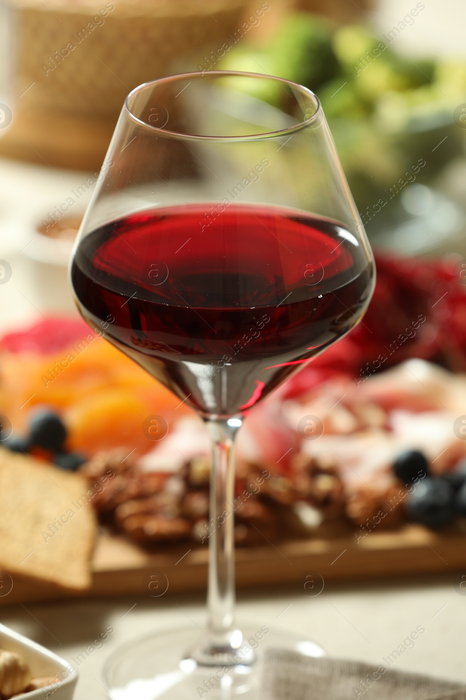 Photo of Red wine and different snacks served on table, closeup