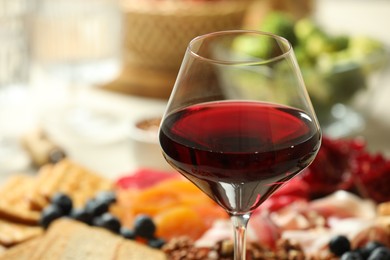 Photo of Red wine and different snacks served on table, closeup. Space for text