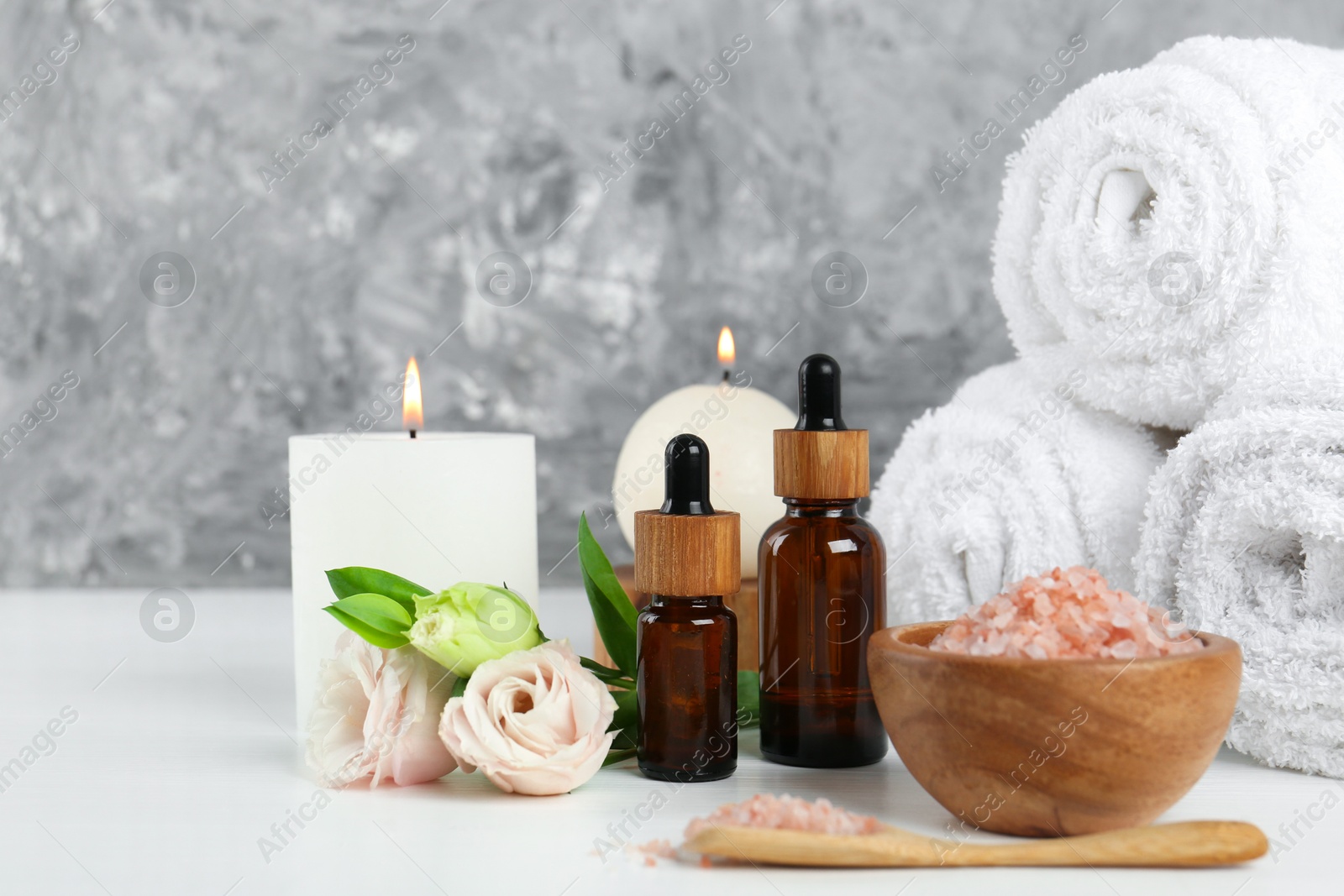 Photo of Spa composition with cosmetic products and towels on white table