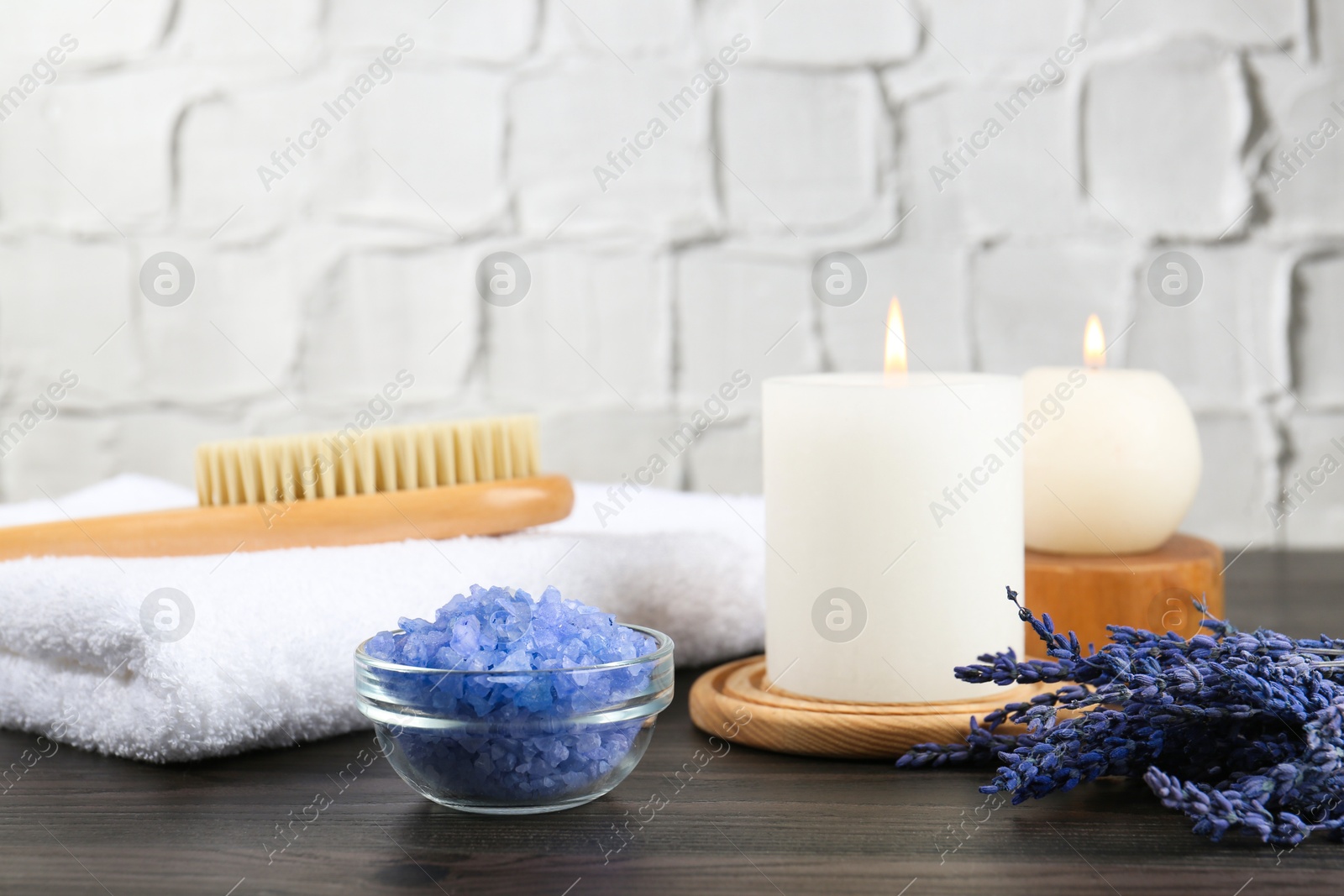 Photo of Spa treatment. Composition with burning candles and towel on wooden table