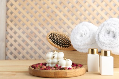 Photo of Composition with towels and cosmetic products for spa treatment on wooden table