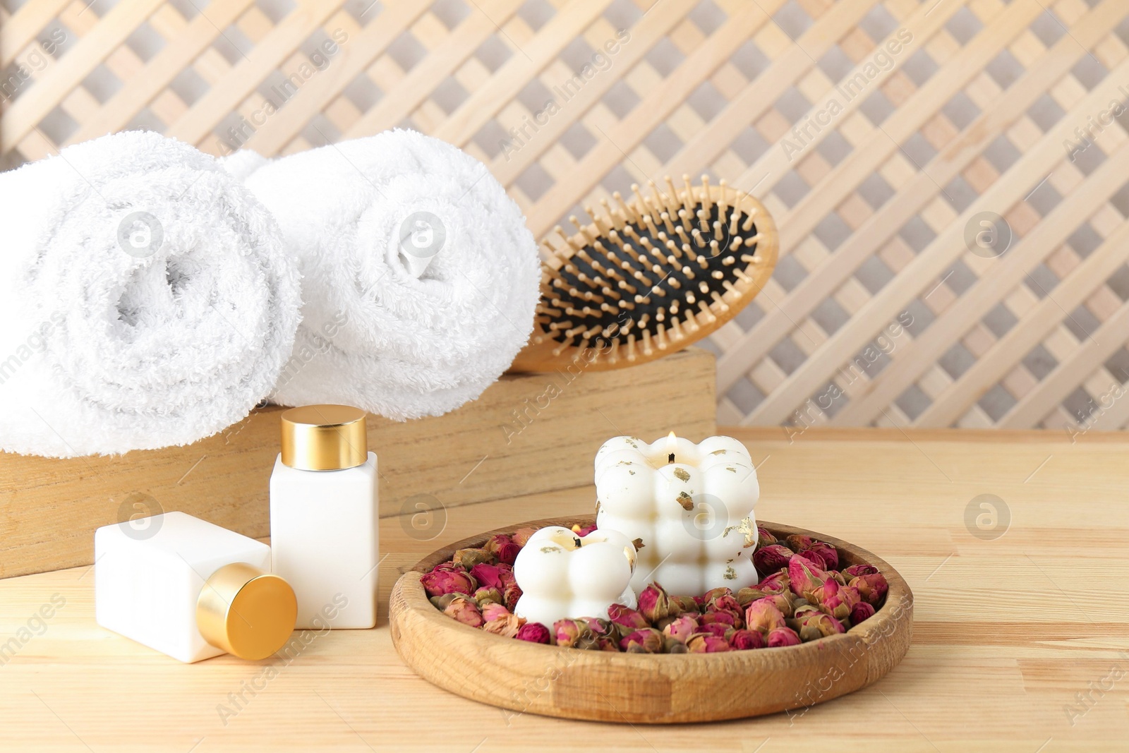 Photo of Composition with towels and cosmetic products for spa treatment on wooden table