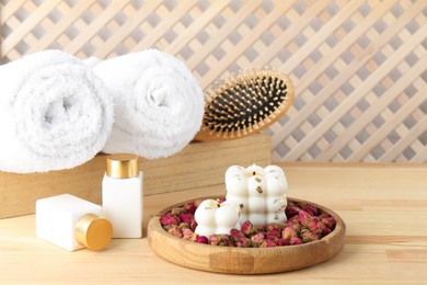 Photo of Composition with towels and cosmetic products for spa treatment on wooden table