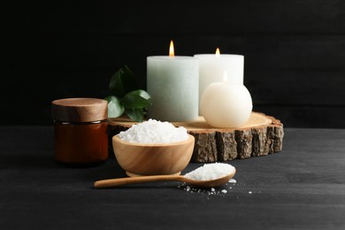 Photo of Composition with cosmetic products and candles for spa treatment on black wooden table