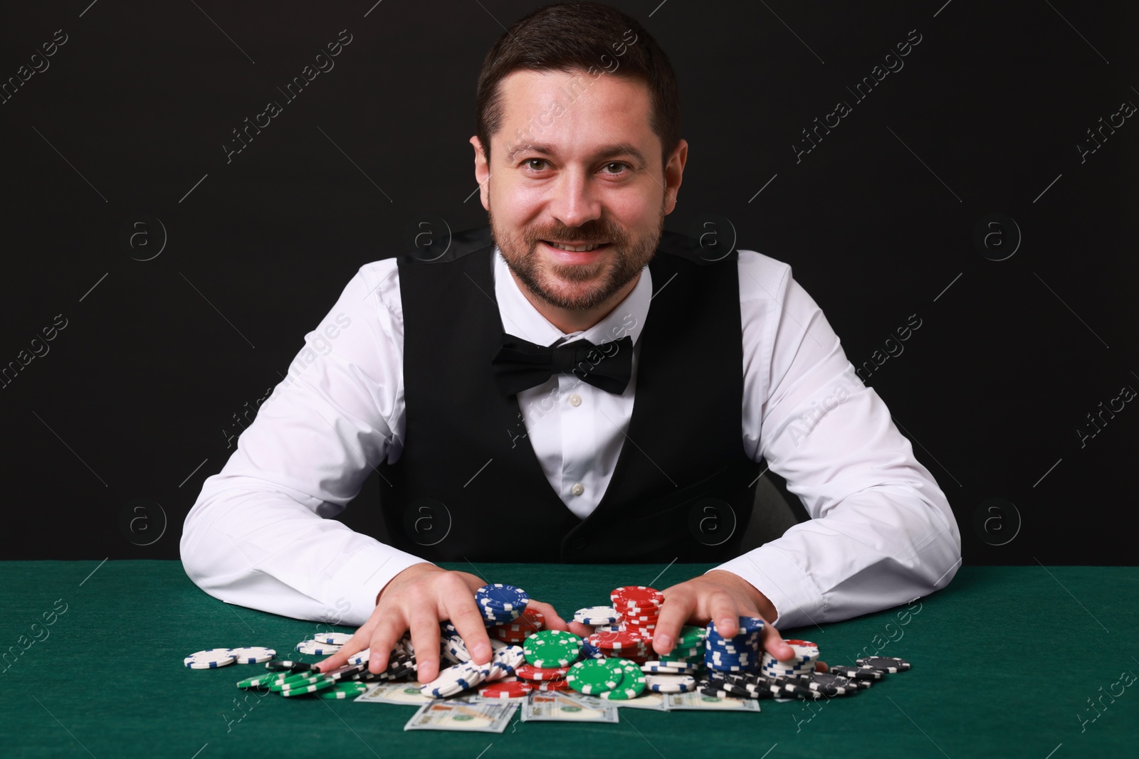 Photo of Professional croupier accepting bets at gambling table