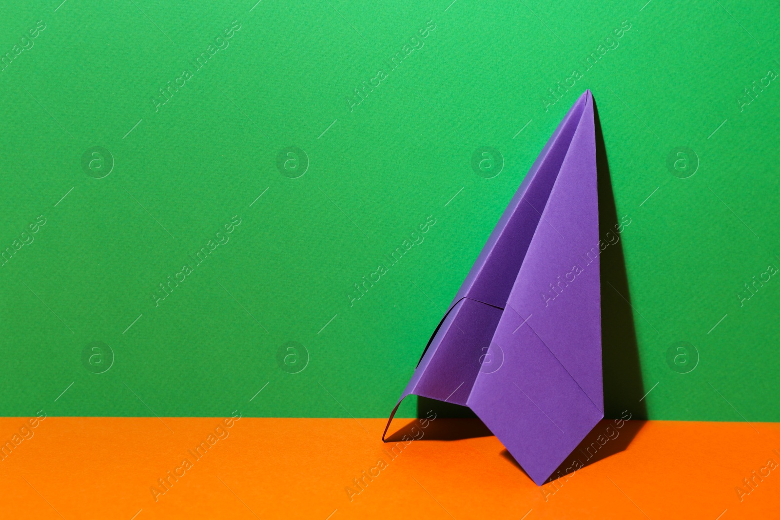 Photo of Handmade purple paper plane on color background. Space for text