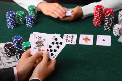 Photo of Gambler making bet near professional croupier at gambling table, closeup