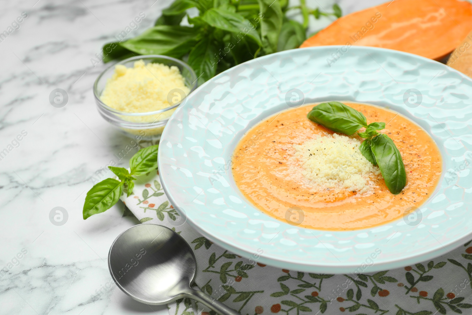 Photo of Delicious sweet potato soup served on white marble table, closeup