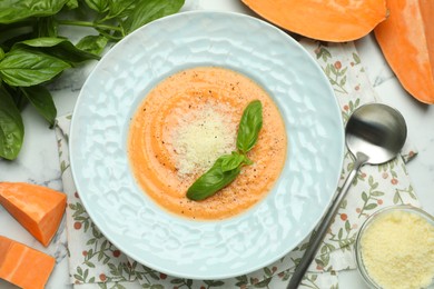 Photo of Delicious sweet potato soup served on white marble table, flat lay